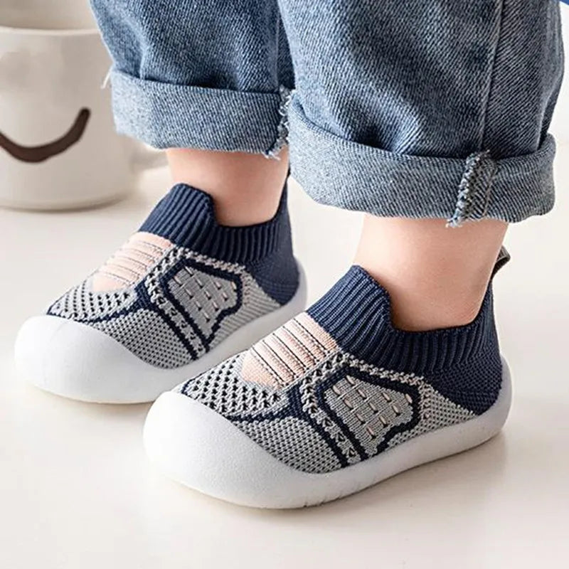 Marineblaue Babyschuhe aus Strick mit grauem Netzgewebe und weißer Gummisohle, detail