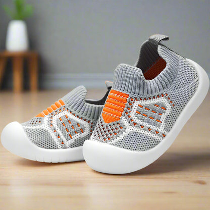 Graue Babyschuhe aus Strick mit orangen Streifen und breiter weißer Gummisohle, detail