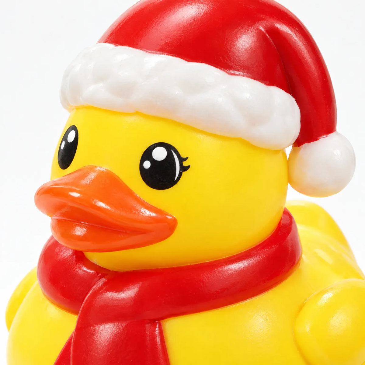 Nahaufnahme eines gelben Gummi-Entchens mit Weihnachtsmütze und rotem Schal, die glänzende Oberfläche und die aufgemalten Augen sind gut zu erkennen. 4