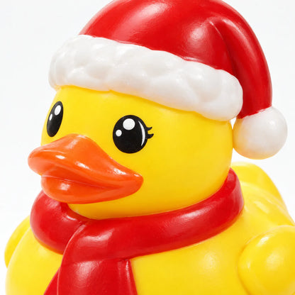 Nahaufnahme eines gelben Gummi-Entchens mit Weihnachtsmütze und rotem Schal, die glänzende Oberfläche und die aufgemalten Augen sind gut zu erkennen. 4