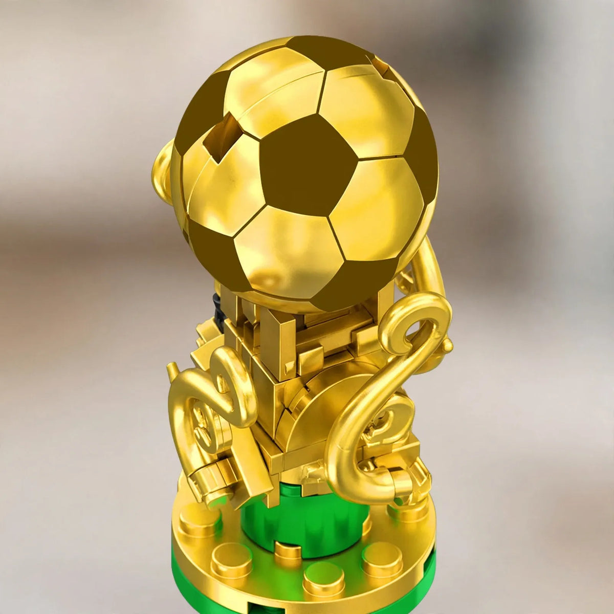 Nahaufnahme des goldenen Fußball-Pokals aus Bausteinen auf grünem Sockel mit geschwungenen Henkeln 3