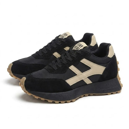 Paar schwarze Sneaker mit beigen Streifen und heller Gummisohle in schräger Vorderansicht 18