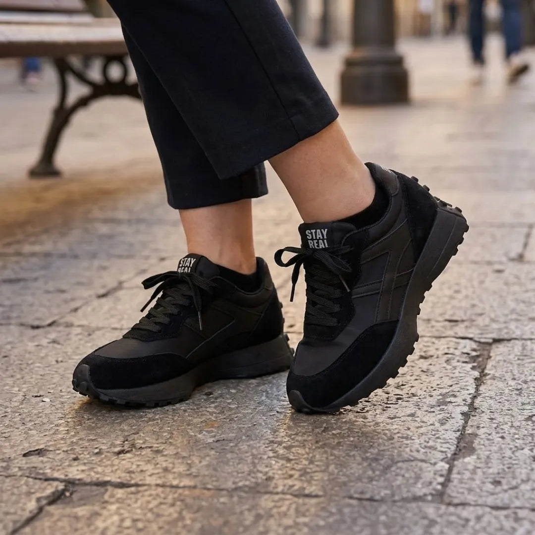 Schwarze Sneaker mit schwarzer Hose auf Steinpflaster getragen, mit schwarzen Schnürsenkeln 7