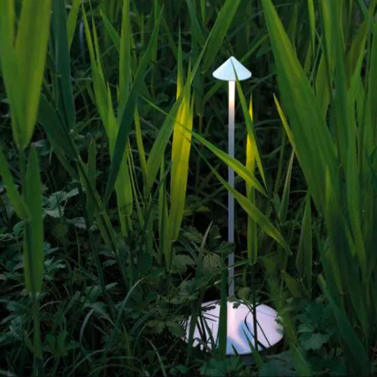 Weiße Lampe steht leuchtend im hohen grünen Gras und wirkt als Gartenlicht 16