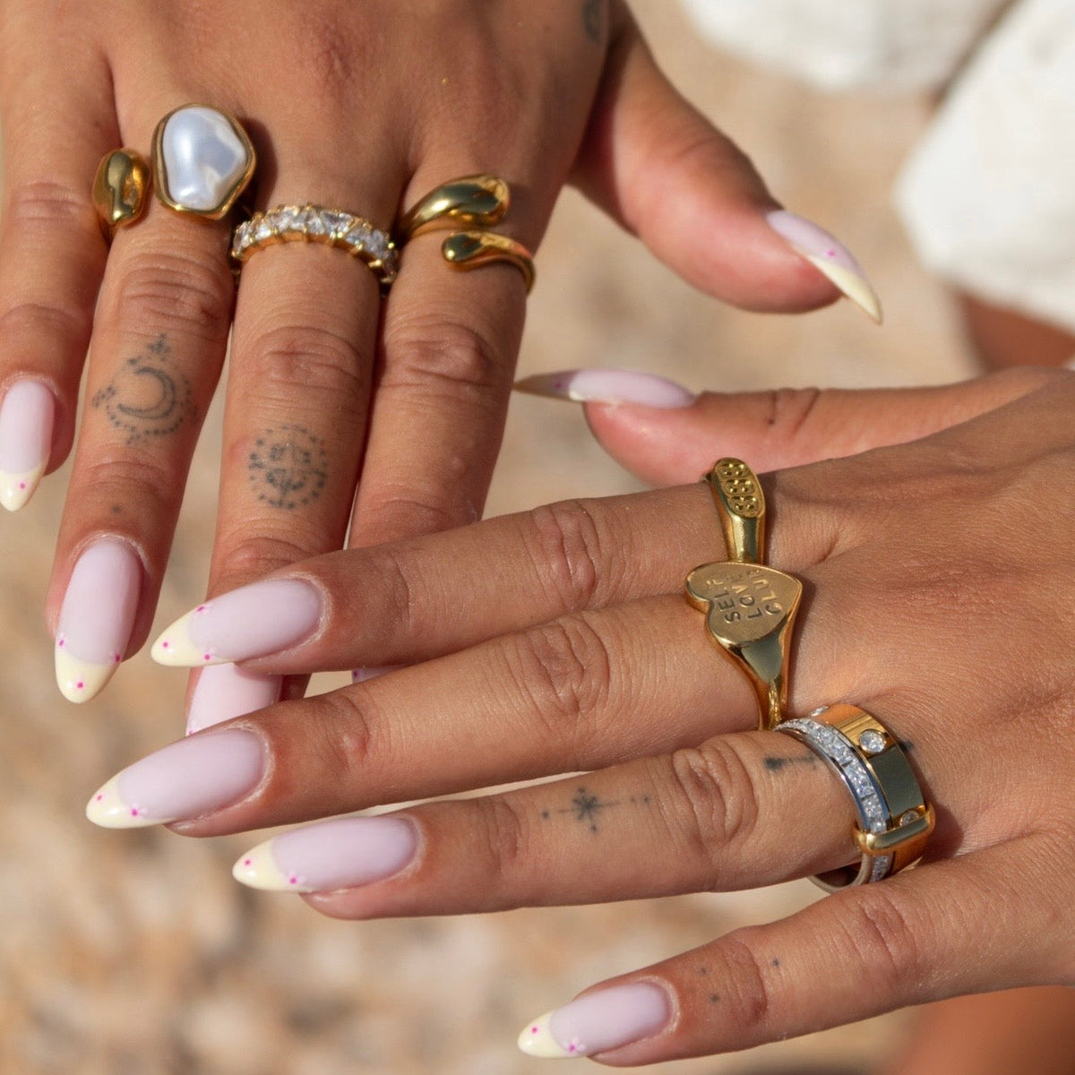 Zwei Hände mit dem zweifarbigen Ring am Zeigefinger, getragen zusammen mit mehreren goldenen Ringen 4