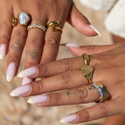 Zwei Hände mit dem zweifarbigen Ring am Zeigefinger, getragen zusammen mit mehreren goldenen Ringen 4
