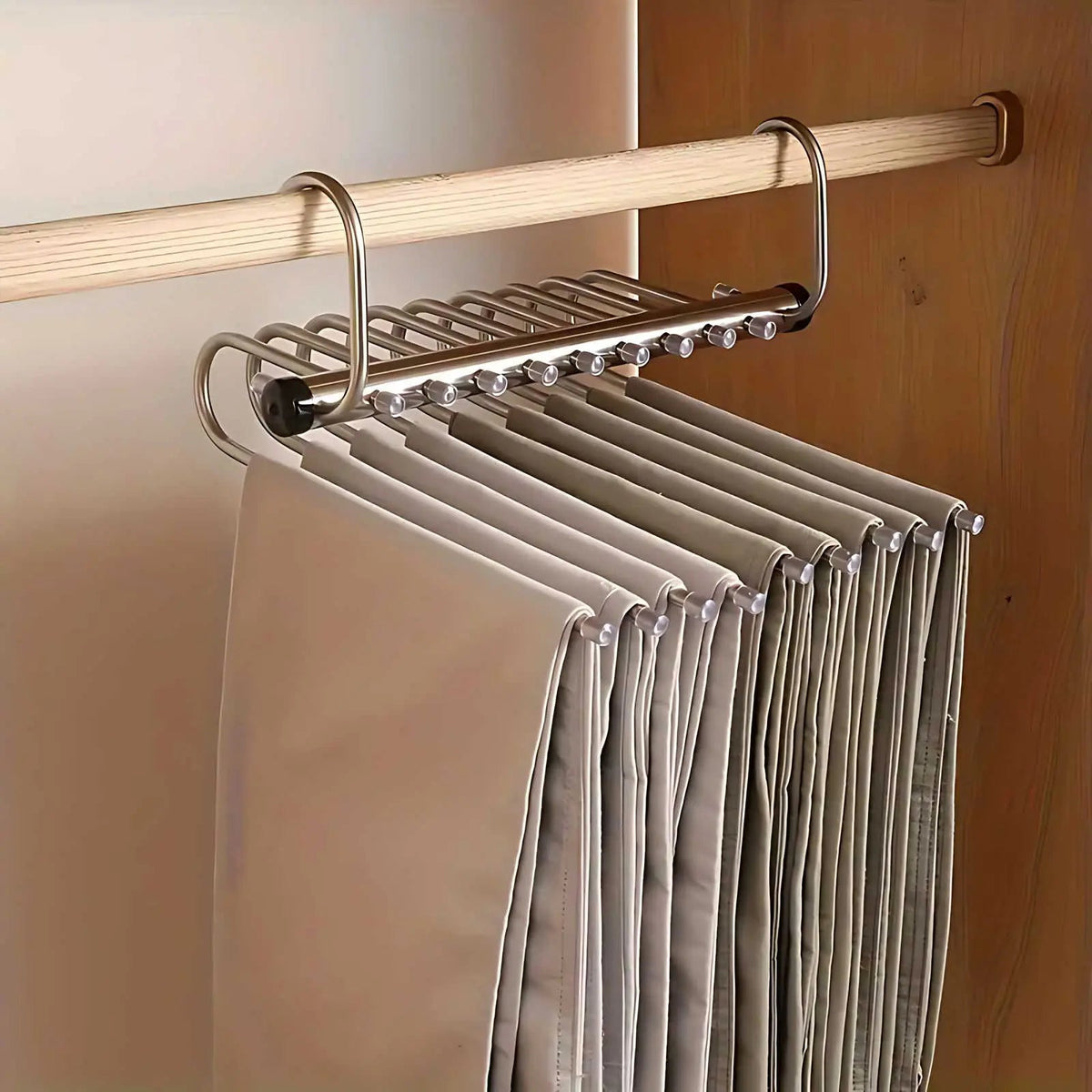 Seitenansicht des waagerecht ausgeklappten Bügels an der Kleiderstange, die Hosen hängen nebeneinander an den Stiften der Metallbögen. 5