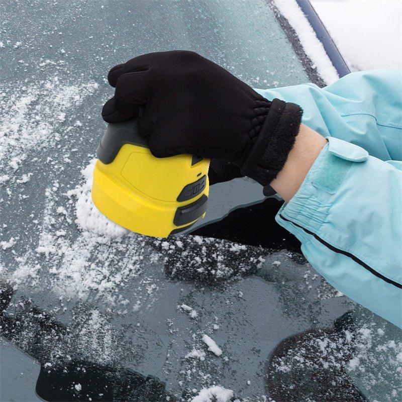 Hand im schwarzen Handschuh führt den gelben Eiskratzer über eine mit Schnee bedeckte Autoscheibe 4