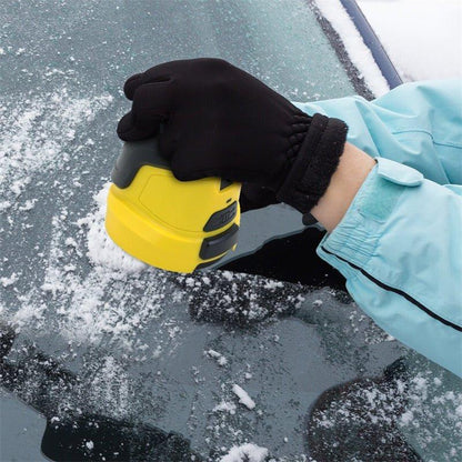 Hand im schwarzen Handschuh führt den gelben Eiskratzer über eine mit Schnee bedeckte Autoscheibe 4