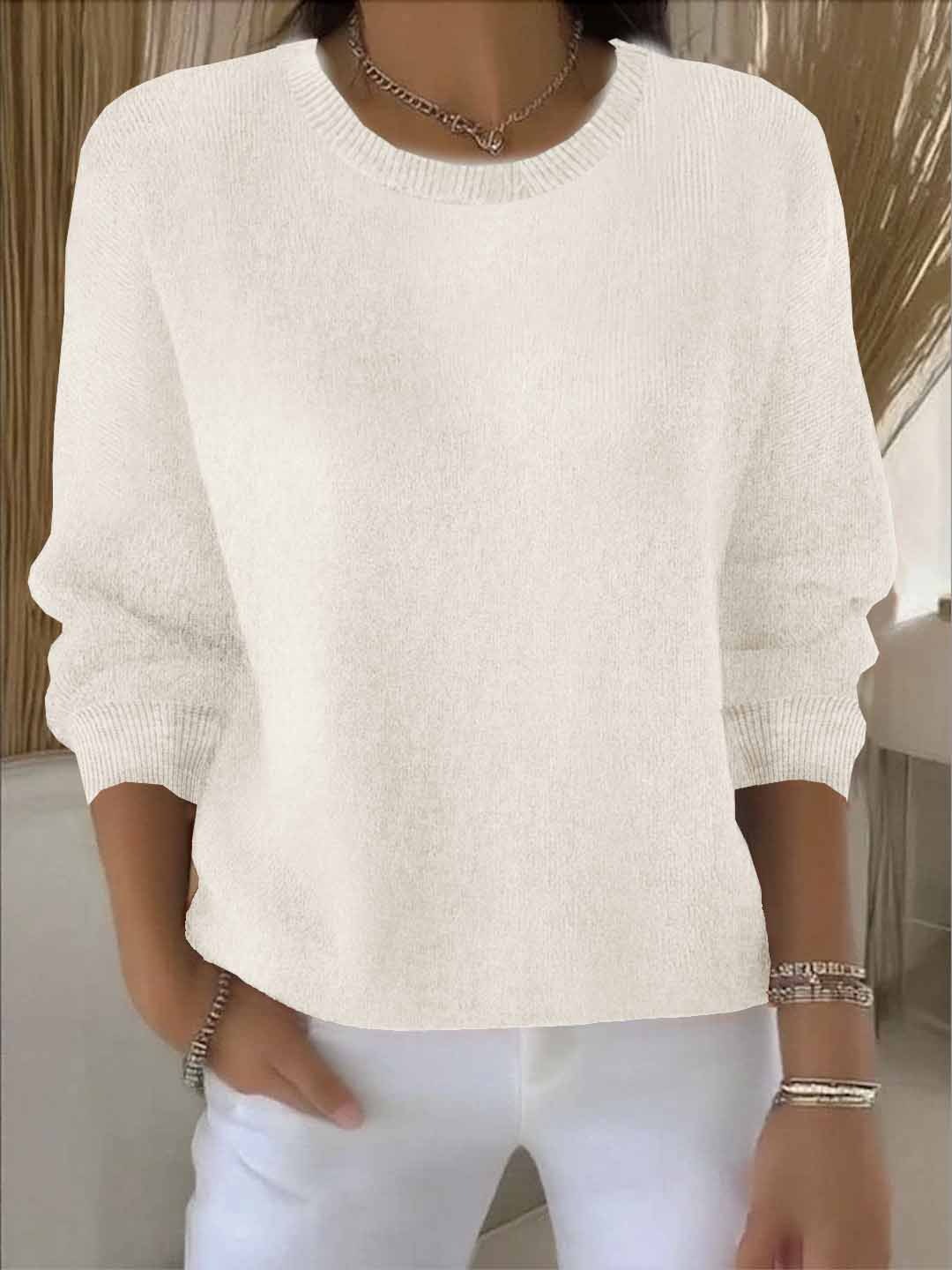 Model im Strickpullover in Creme mit Rundhalsausschnitt, kombiniert mit weißer Hose und Armbändern 4