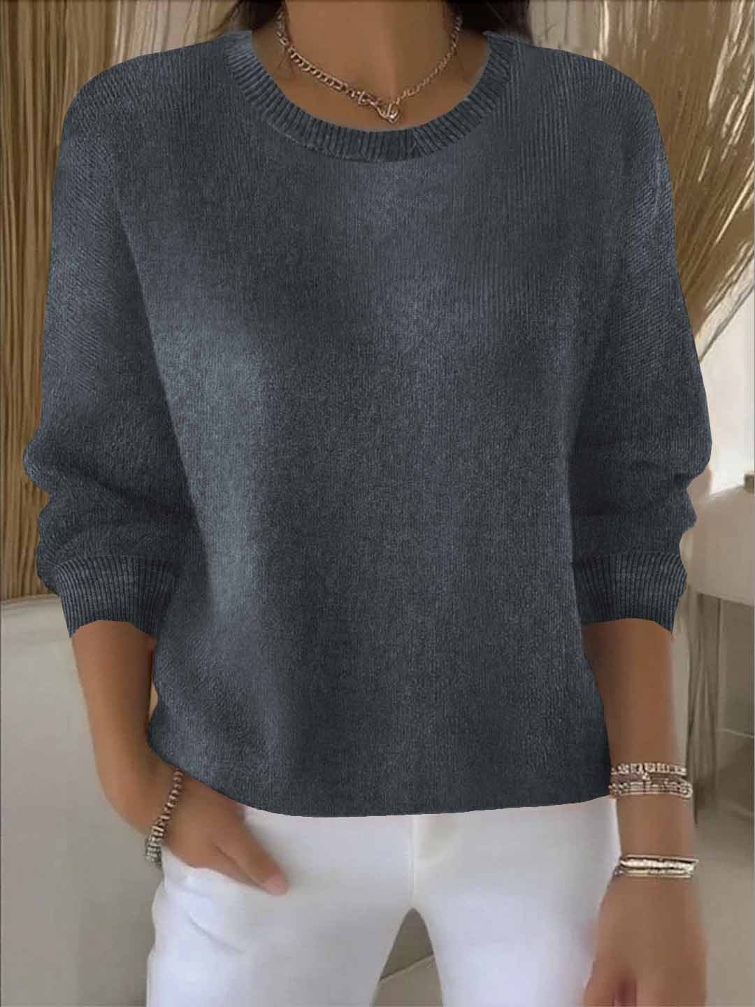 Frontansicht des Pullovers in Anthrazit mit Rundhals, getragen von einem Model mit weißer Hose 6