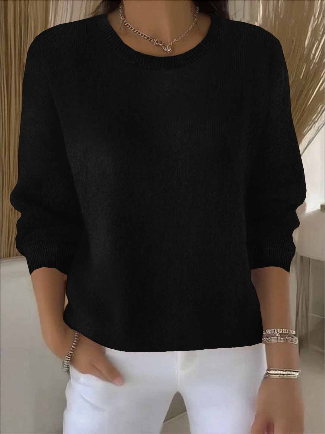 Schwarzer Strickpullover mit Rundhalsausschnitt, getragen zu weißer Hose, Hand in der Hosentasche 7