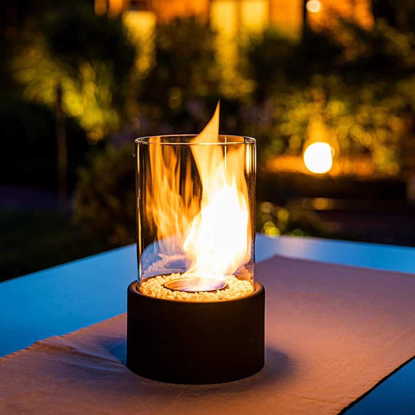 Glas-Feuerstelle mit Flamme, Tischdekoration, Outdoor, modern, schwarz, stimmungsvoll, Nacht.