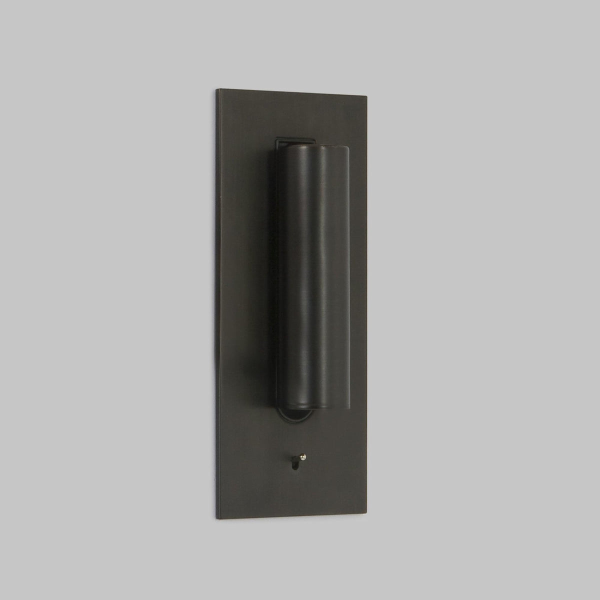 Lampe in dunklem Bronzeton mit eingeklapptem Strahlerrohr, schräg von der Seite vor grauer Wand 2