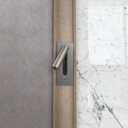 Wandleuchte in mattem Nickel in einer Holzleiste zwischen grauer Stofffläche und weißem Marmor 33