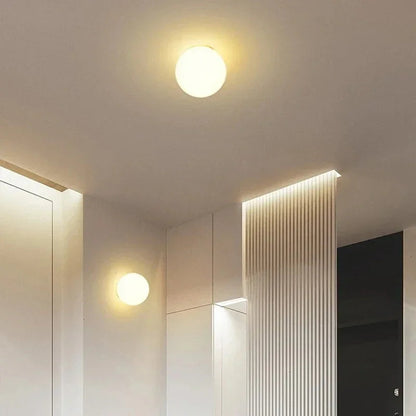 Zwei Kugelleuchten, eine an der Decke, eine an der Wand, in einem Flur mit Lichtleisten 10