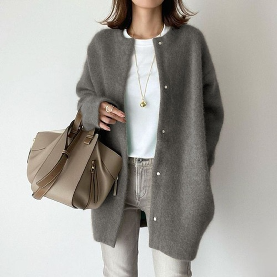 Flauschiger Cardigan in Grau mit Druckverschluss, getragen zu weißem Shirt, hellgrauer Jeans und beiger Handtasche 6