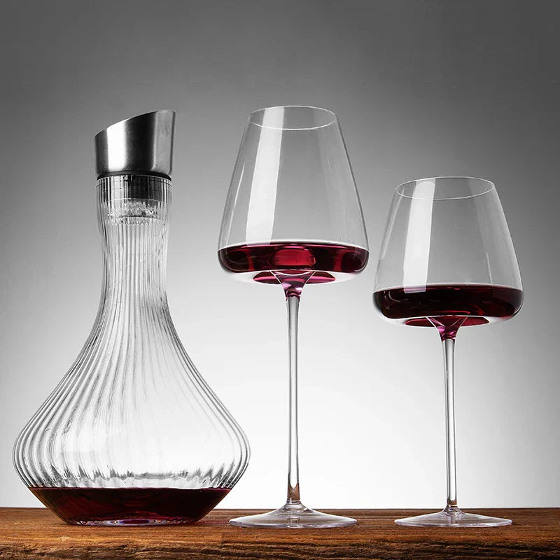 Gerippte Glaskaraffe und zwei mit Rotwein gefüllte Gläser auf einem Holztisch vor grauem Hintergrund 4