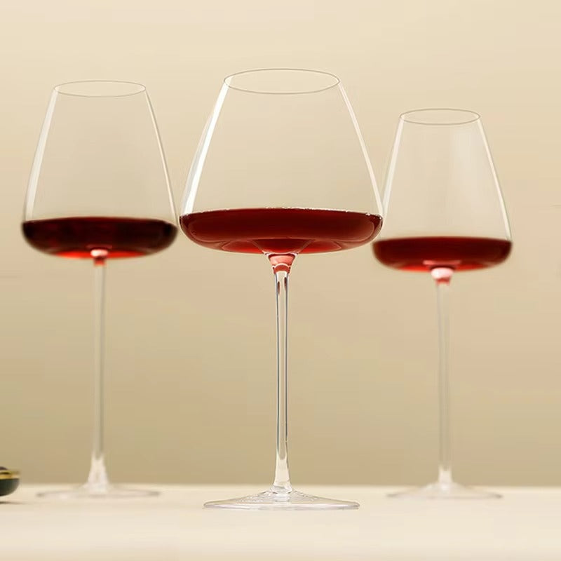 Drei unterschiedlich große Gläser mit Rotwein nebeneinander vor beigem Hintergrund 10