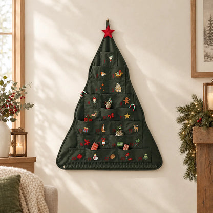Dunkelgrüner Adventskalender in Baumform hängt an einer hellen Wand im weihnachtlich dekorierten Wohnzimmer, mit roter Stoffsternspitze und kleinen Fächern. 1
