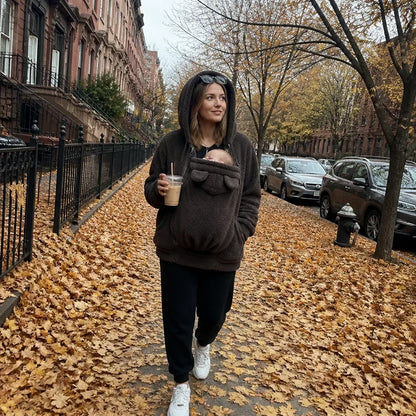 Beiger Sherpa-Fleece-Hoodie, Detail mit eingezipptem Babytrageeinsatz auf der Straße.