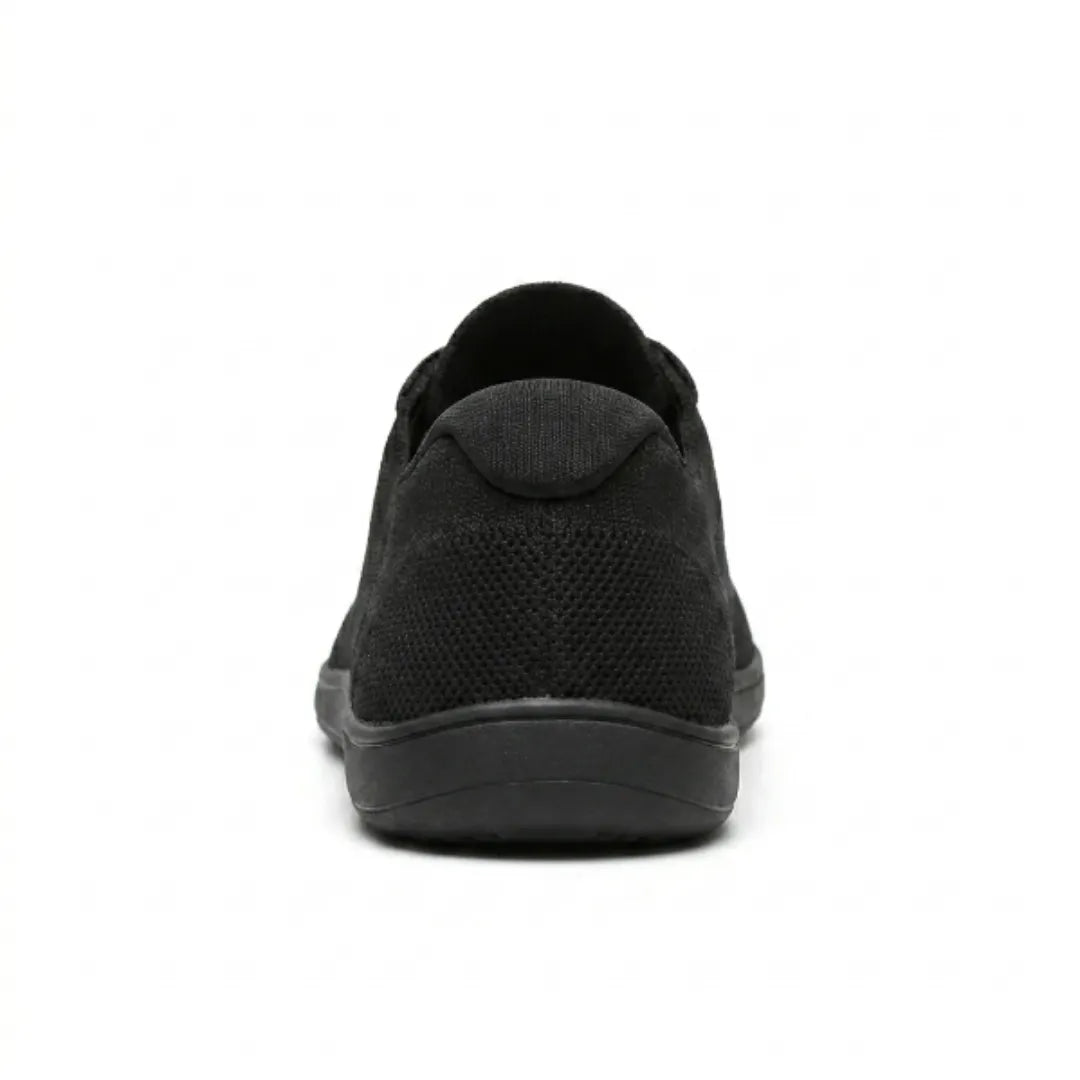 Schwarzer Sneaker von hinten mit Blick auf Fersenkappe, Netzstruktur und flache, breite Sohle. 18