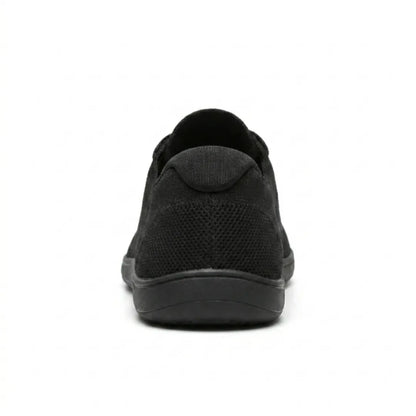 Schwarzer Sneaker von hinten mit Blick auf Fersenkappe, Netzstruktur und flache, breite Sohle. 18