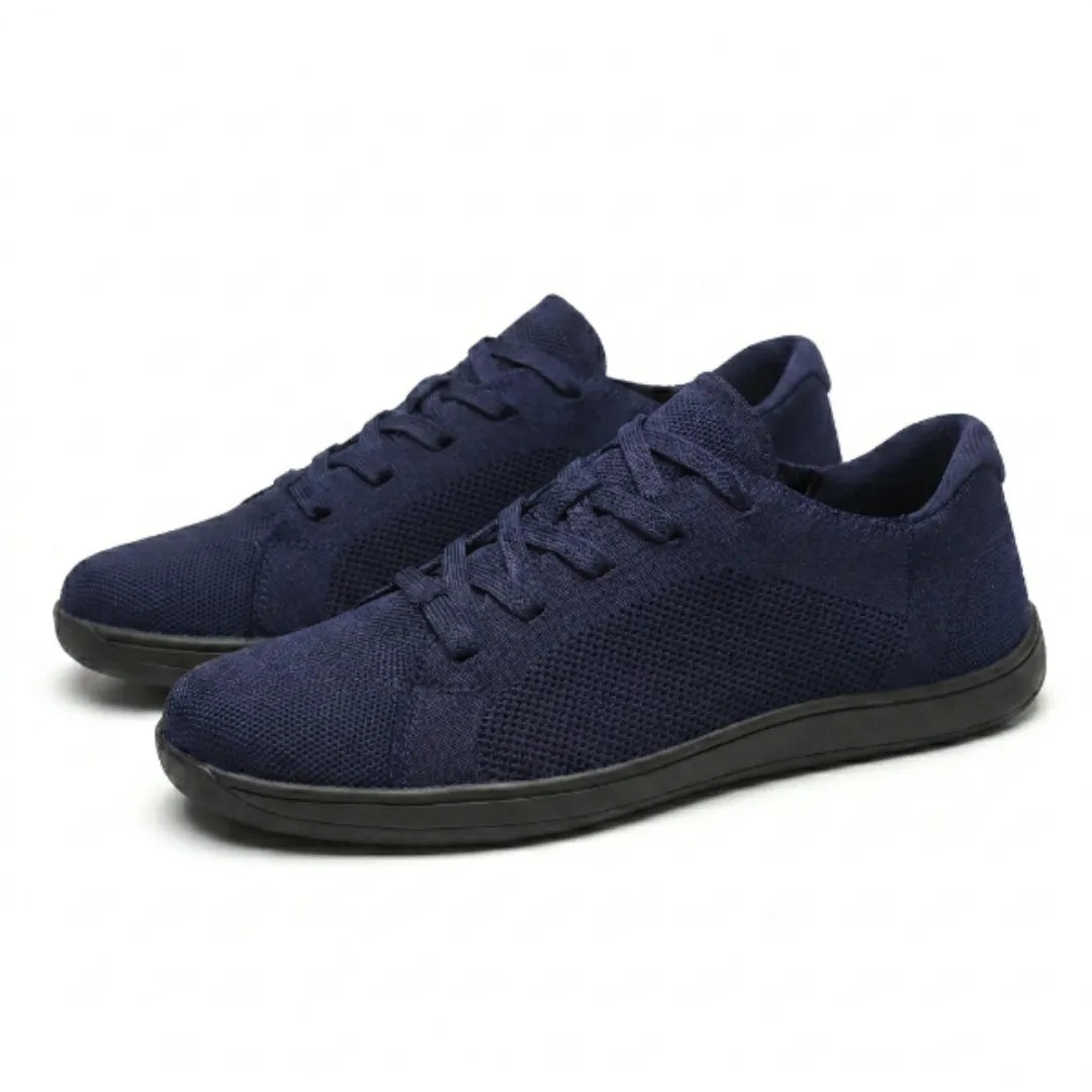 Paar marineblaue Mesh-Sneaker mit schwarzer Sohle und Schnürung, schräg von der Seite auf hellem Hintergrund 25