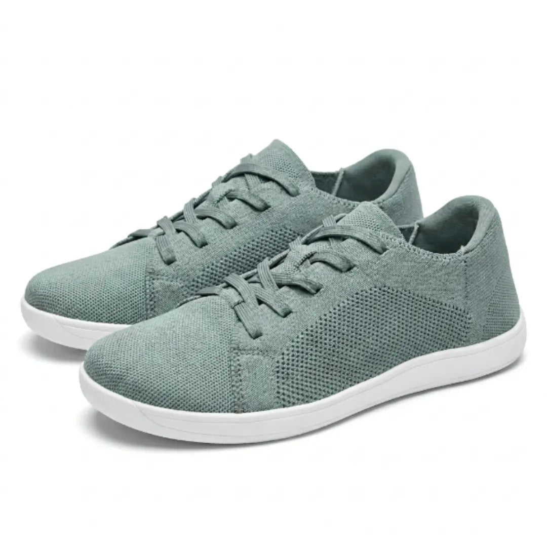 Paar graugrüne Mesh-Sneaker mit weißer Sohle und Schnürung, schräg von der Seite auf hellem Hintergrund 34