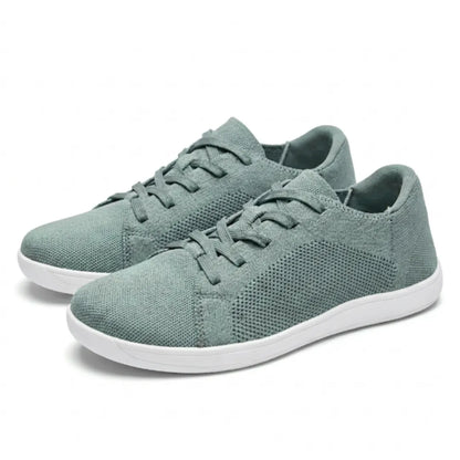 Paar graugrüne Mesh-Sneaker mit weißer Sohle und Schnürung, schräg von der Seite auf hellem Hintergrund 34