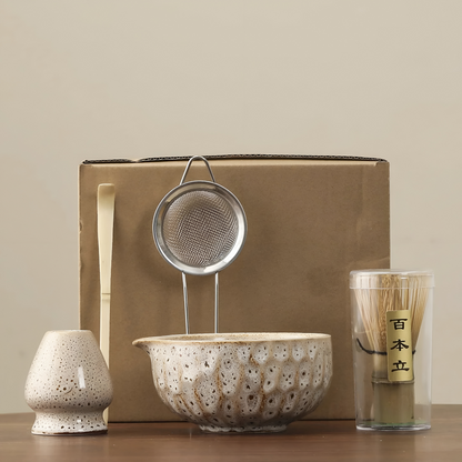 5-teiliges Matcha-Set in cremeweißer Glasur mit braunen Sprenkeln vor einem braunen Versandkarton