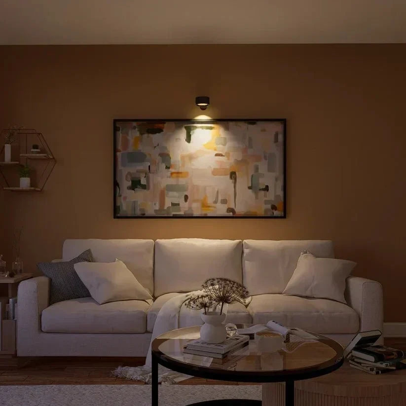 Schwarze Wandleuchte beleuchtet ein abstraktes Gemälde über einem hellen Sofa im Wohnzimmer 15