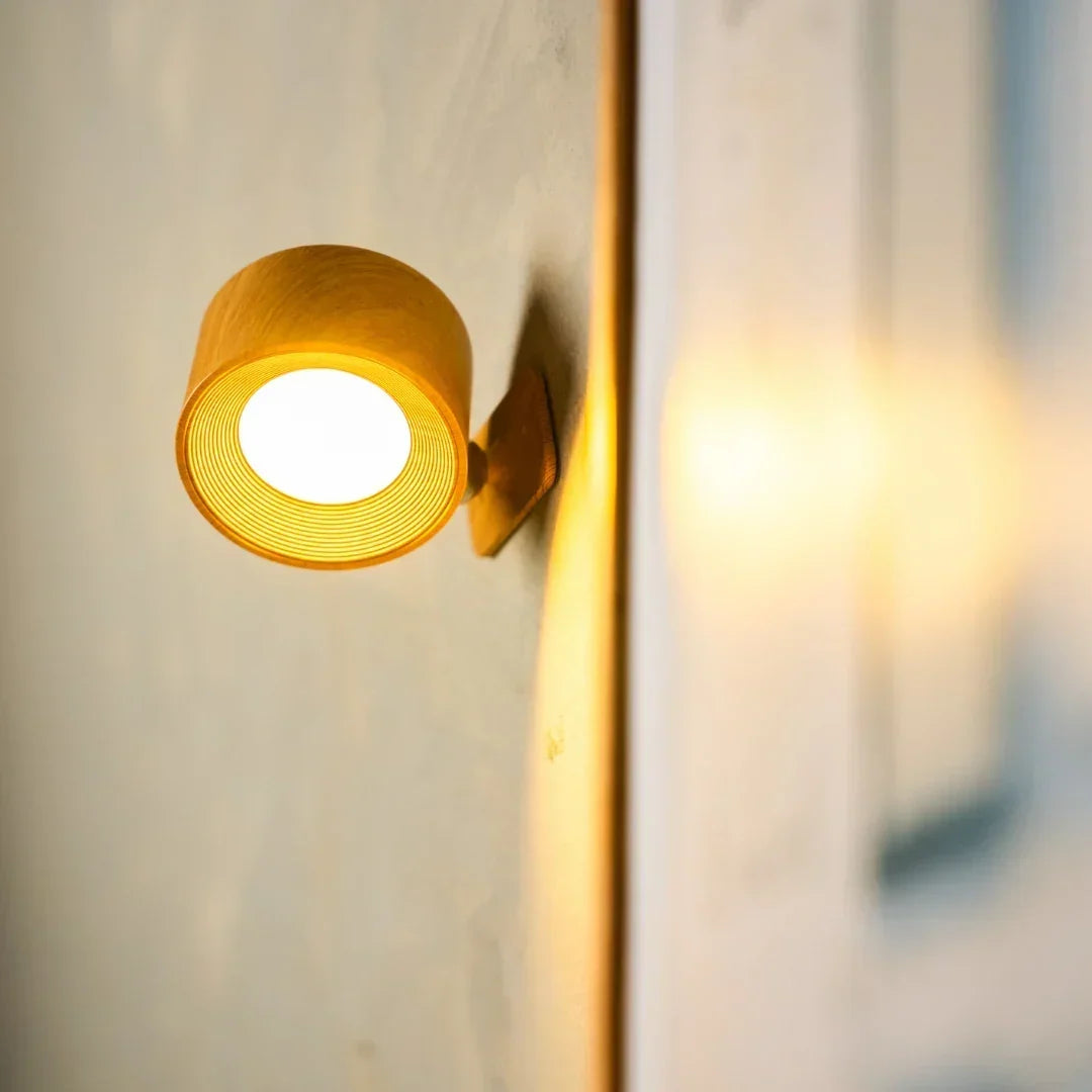 Nahaufnahme der leuchtenden Wandleuchte in Holzoptik mit warmem Licht an einer hellen Wand 1
