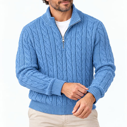 Mann trägt den hellblauen Zopfstrickpullover mit halbem Reißverschluss und Stehkragen, Nahaufnahme von Oberkörper und Händen vor weißem Hintergrund. 1