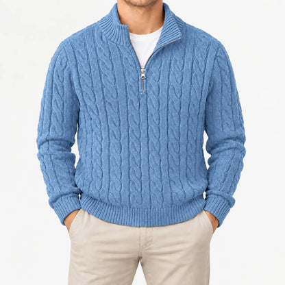 Hellblauer Zopfstrickpullover mit geöffnetem Halbreißverschluss und Stehkragen, frontal am Model mit beiger Hose. 11