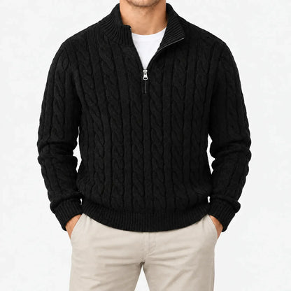 Schwarzer Zopfstrickpullover mit Halbreißverschluss und Stehkragen, frontal am Model mit beiger Hose vor weißem Hintergrund. 13