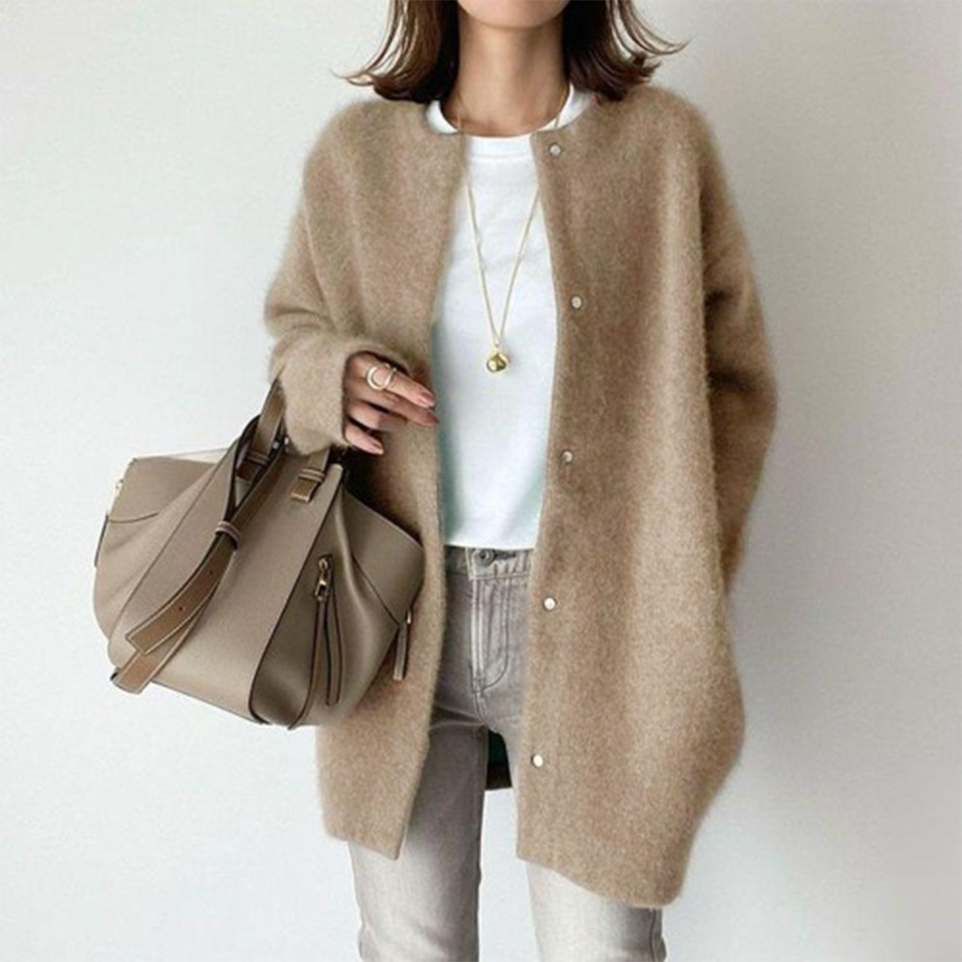 Flauschiger Cardigan in Beige mit Druckknöpfen, getragen zu weißem Shirt, hellgrauer Jeans und Handtasche 1