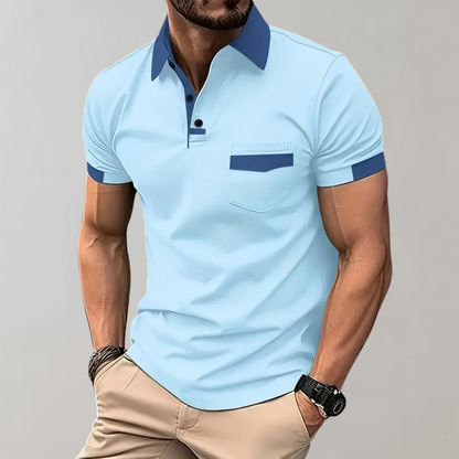 Von einem Model getragenes hellblaues Poloshirt mit dunkelblauem Kragen, Brusttasche und Ärmelbündchen, kombiniert mit beiger Hose.