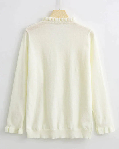 Weiße Damenstrickjacke mit Rüschenkragen, langärmelig, aus weichem Material, elegant und stilvoll.