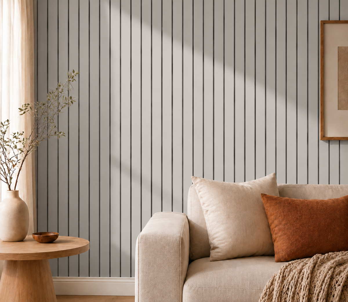 Graue Lamellenwand im Streiflicht neben Sofa mit Kissen, Beistelltisch und Vase 16