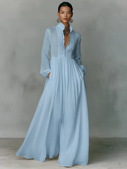 Das Maxikleid in Hellblau, getragen von einem Model, Frontansicht mit Stehkragen und Knopfleiste 3