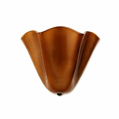 Karamellbraune glänzende Wandlampe mit welligem Rand und dunklem Knopf.