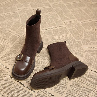 Braune Wildlederstiefel mit Lederkappe und Schnalle, liegend mit sichtbarer profilierter Gummisohle und Blockabsatz.