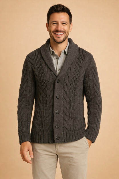 Frontale Halbfigur der dunkelgrauen Strickjacke mit Zopfmuster, Schalkragen, Knopfleiste und aufgesetzten Taschen, getragen über grauem Hemd. 5