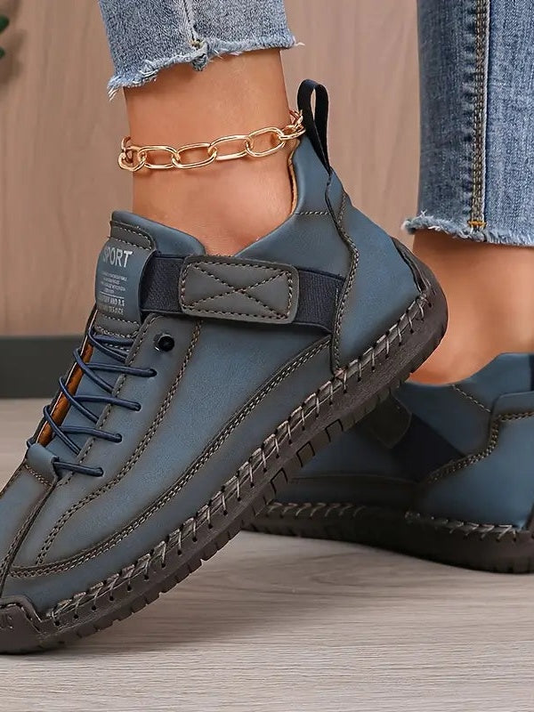 Blaugraue Sneaker an den Füßen einer Frau, Seitenansicht mit Schnürung und Klettband 9