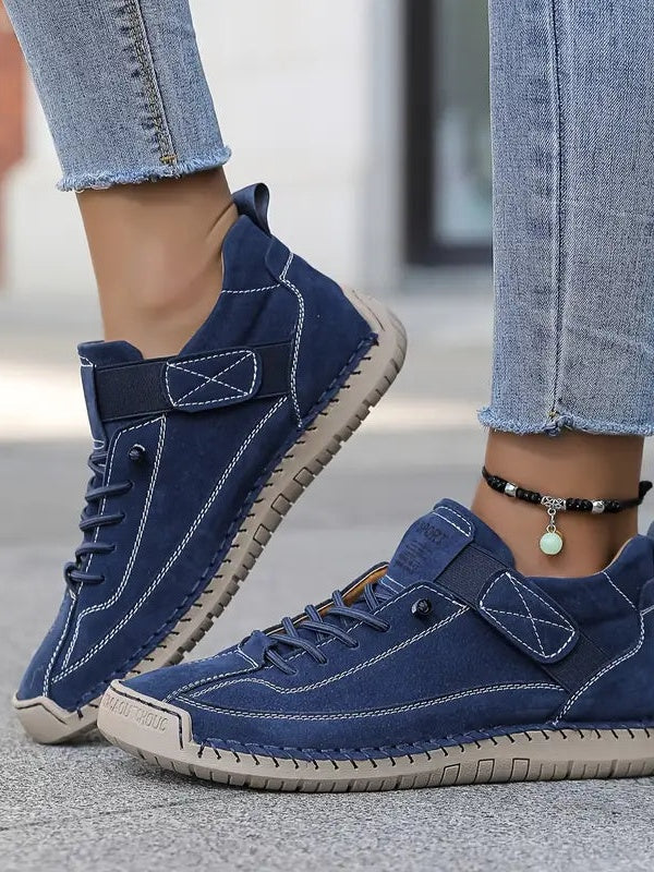 Blaue Sneaker an den Füßen einer Frau in Jeans, Draufsicht mit Klettband und heller Sohle 3