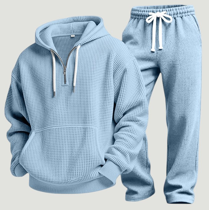 Hellblaues Waffelstrick-Set aus Hoodie mit halbem Reißverschluss und Jogginghose mit weißem Kordelzug, freigestellt nebeneinander. 6