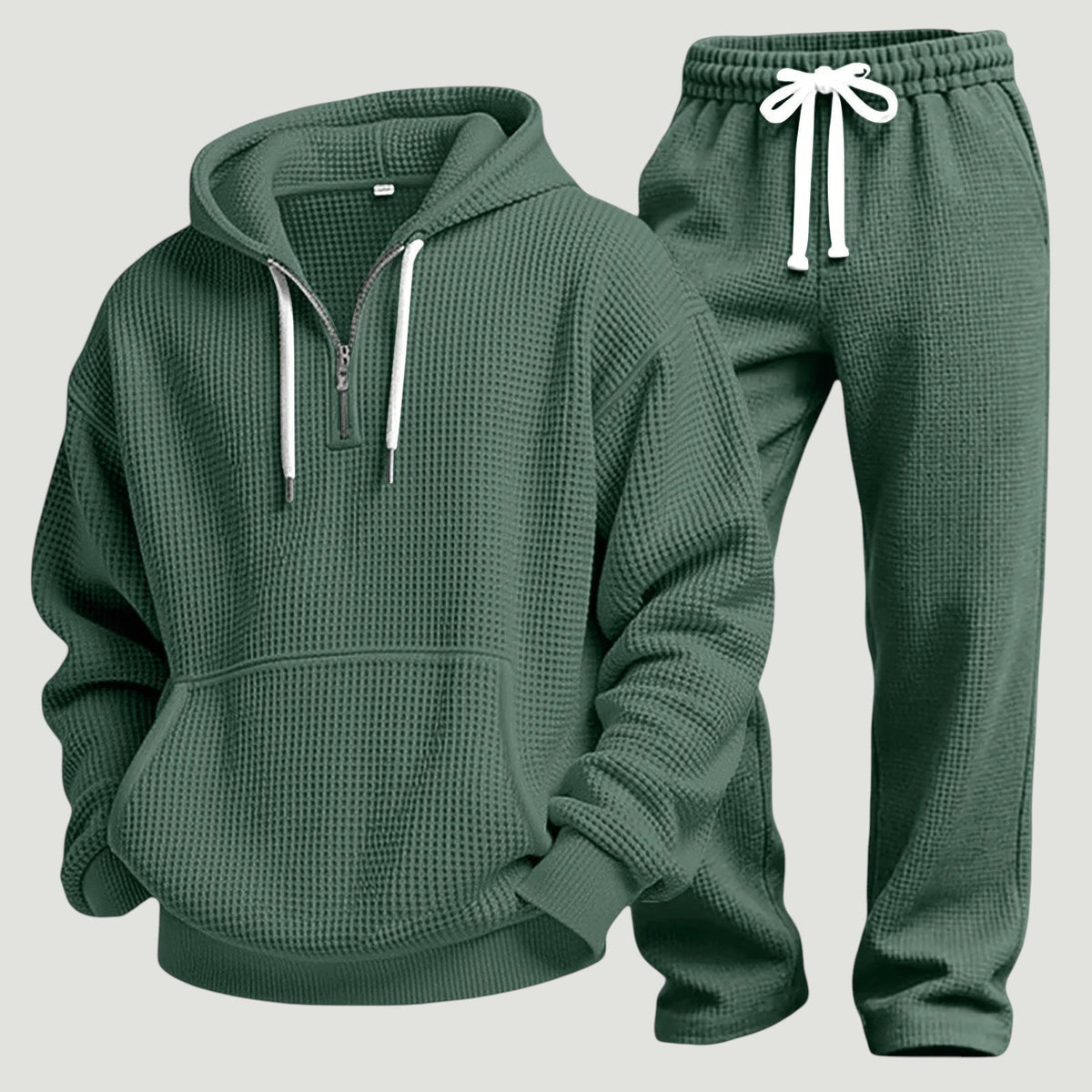 Grünes Waffelstrick-Set aus Hoodie mit Kängurutasche und Jogginghose mit weißem Kordelzug, freigestellt nebeneinander. 11