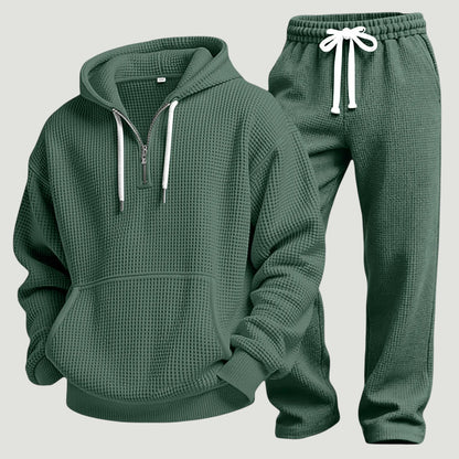 Grünes Waffelstrick-Set aus Hoodie mit Kängurutasche und Jogginghose mit weißem Kordelzug, freigestellt nebeneinander. 11