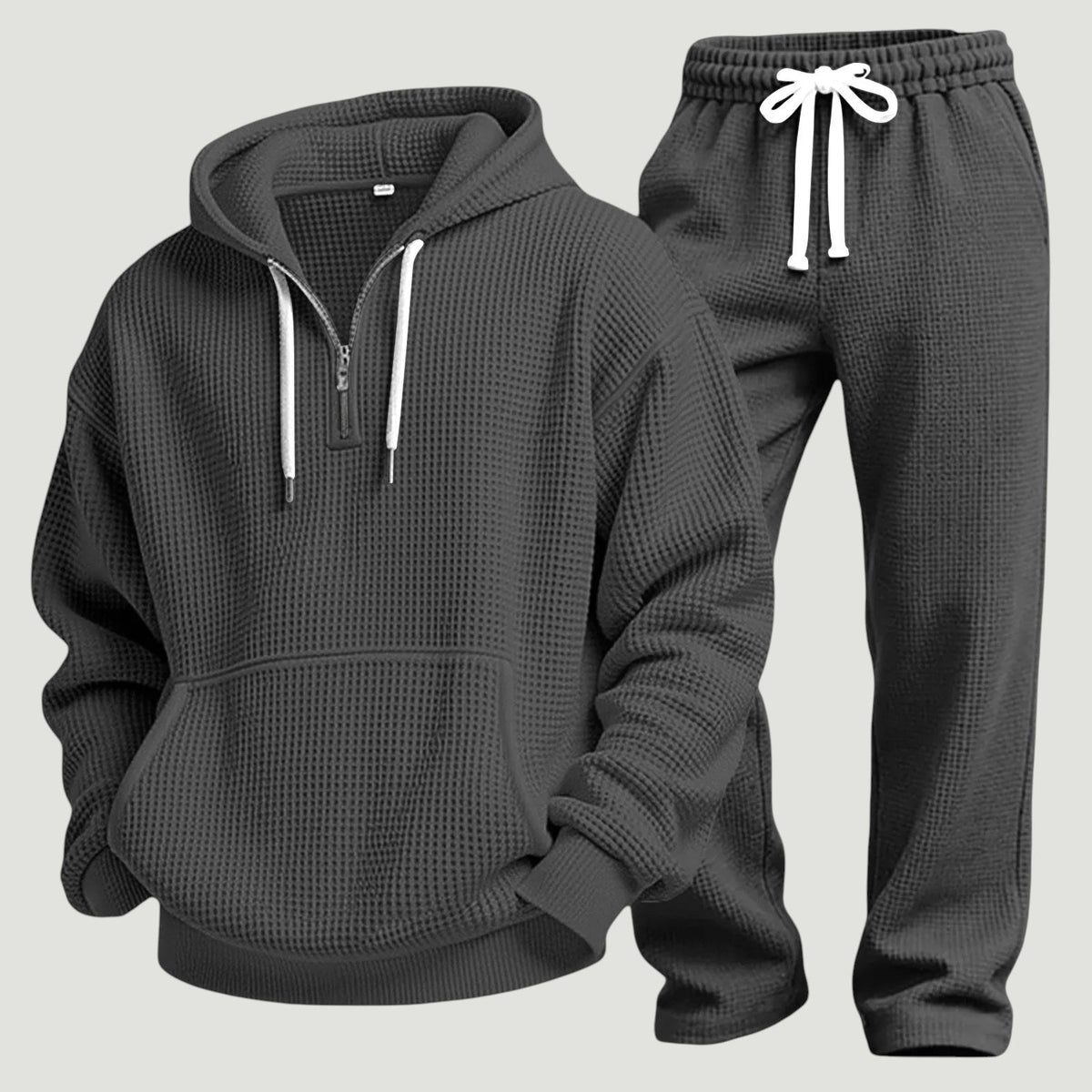 Dunkelgraues Waffelstrick-Set aus Hoodie mit Känguru-Tasche und Jogginghose mit weißem Kordelzug, freigestellt nebeneinander. 7